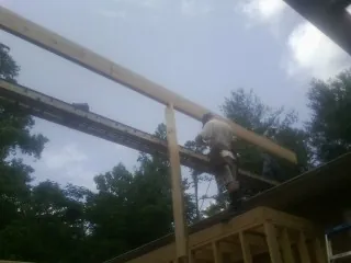Carpenter setting a ridge beam over a new addition frame — Ice Dam Removal by Roofing Brothers in Bretz