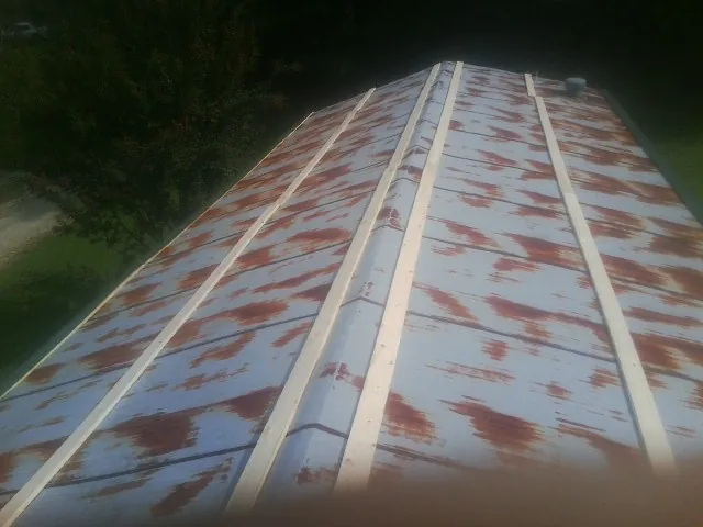 Rusted metal roof panels with new wood purlins before replacement — Storm Damage Roof Repair in Bretz by Roofing Brothers