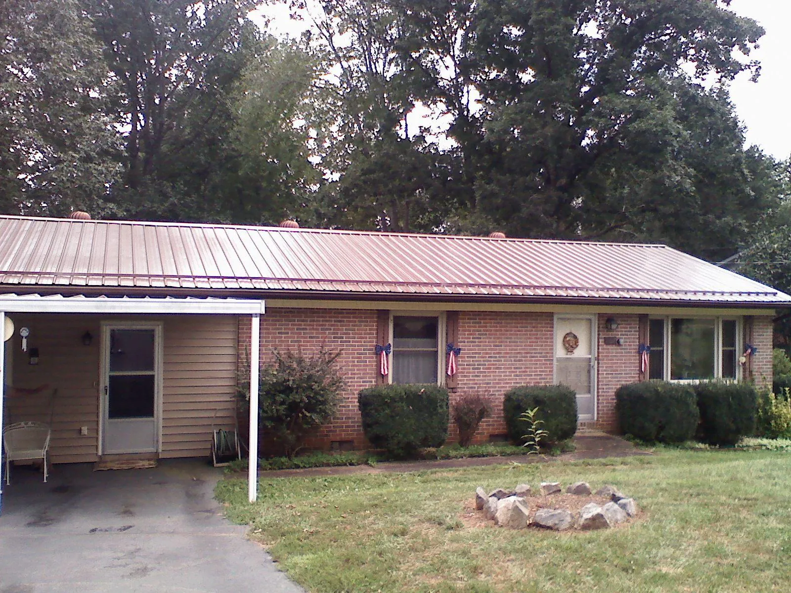 Bronze metal roof and carport on a brick ranch home — Roof Repair work by our crew in Bretz